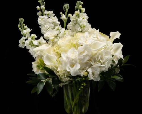 white stock flowers, hydrangea, freesia, calla lilies, and roses